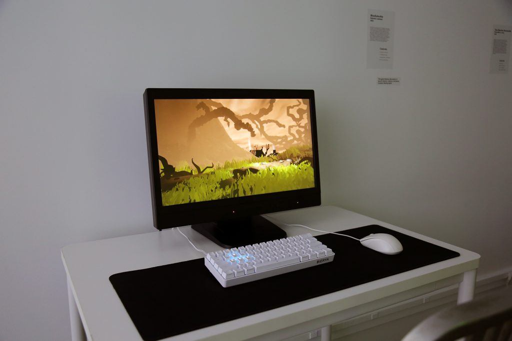 A computer on a white desk with mouse and keyboard.