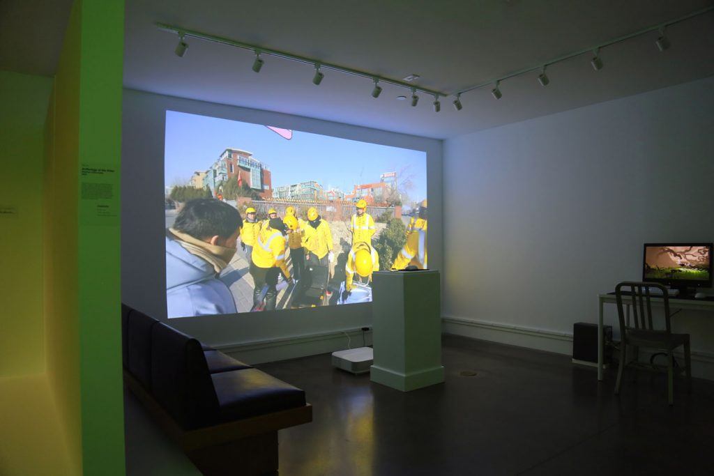 Darkened art gallery with a large projection on the wall.