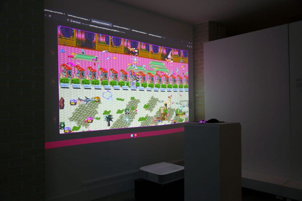 Darkened art gallery with a large projection on the wall.