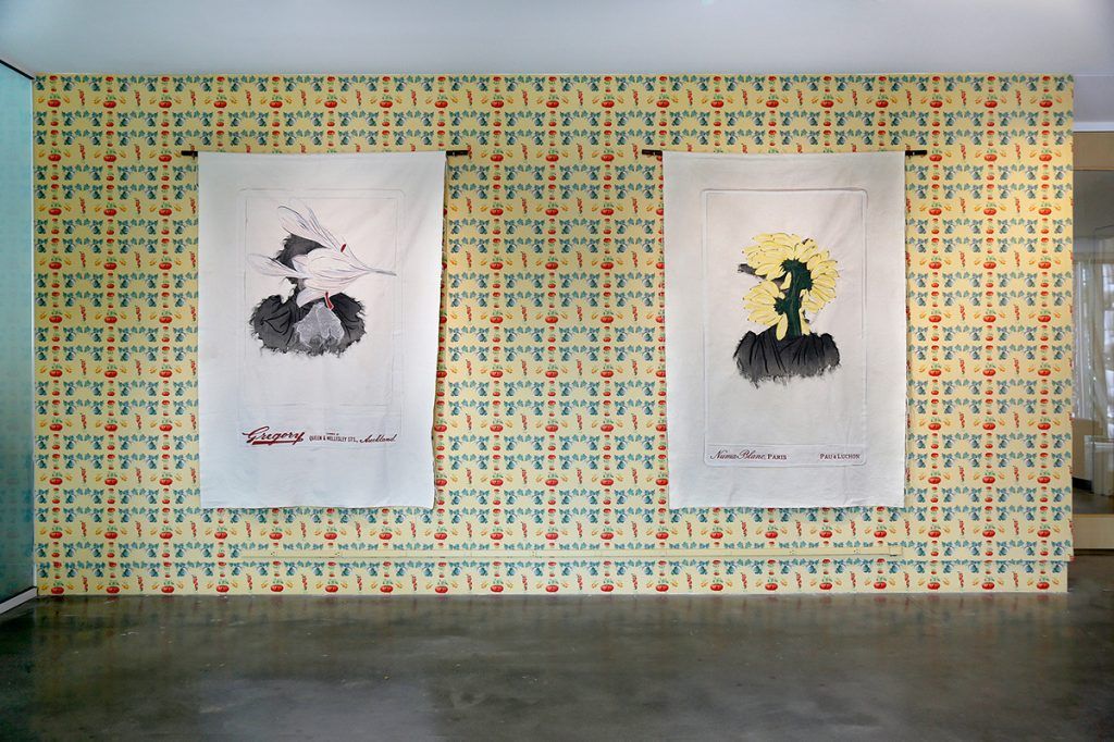 Patterned wallpaper with two large, hanging artworks