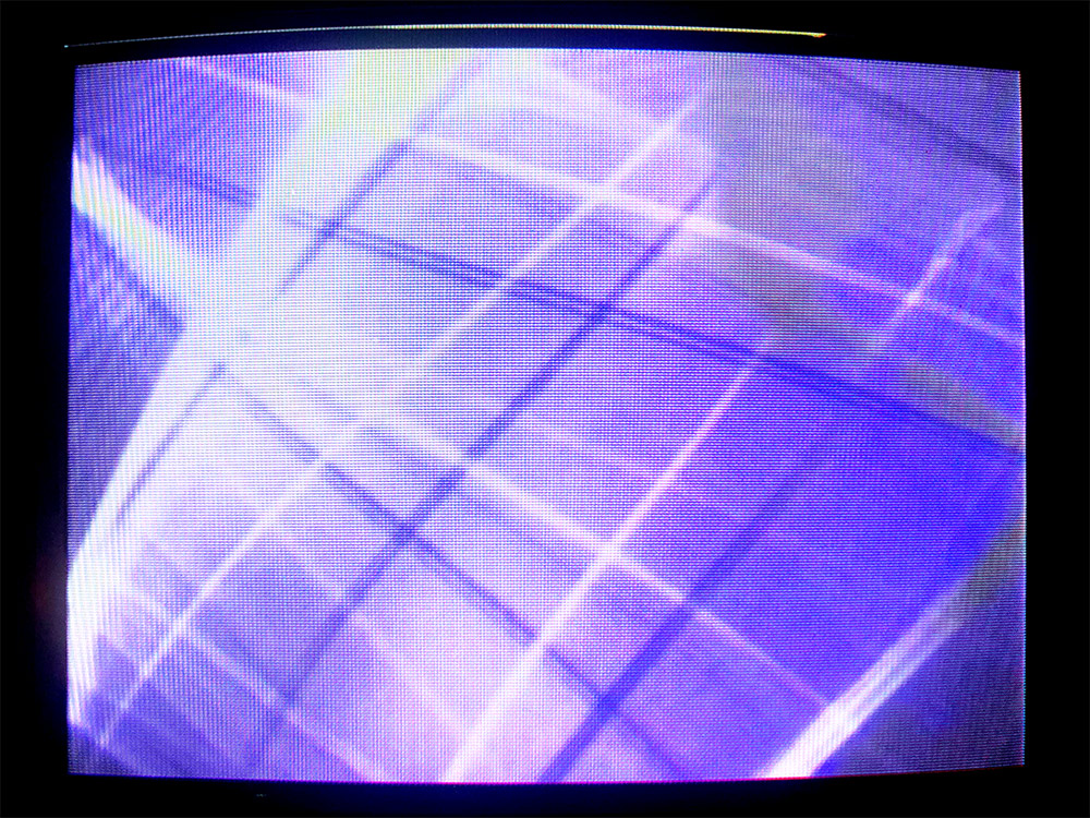 Abstract white and purple lines on a CRT monitor screen.