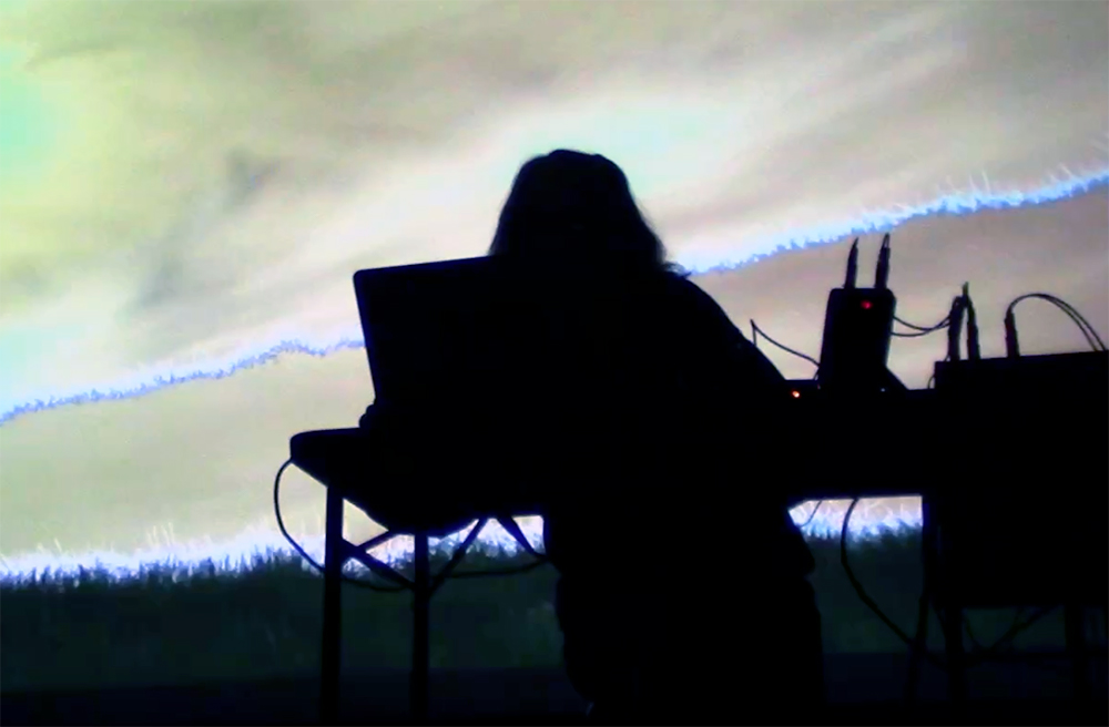 The silhouette of an artist at a computer.