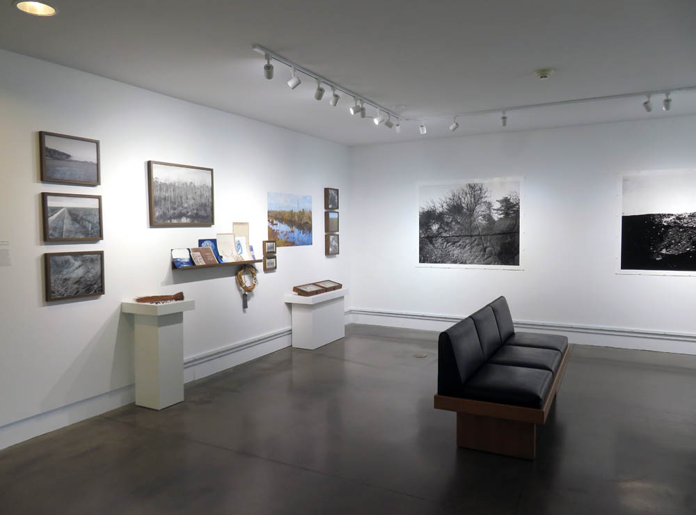 Gallery space with many images installed on the walls.